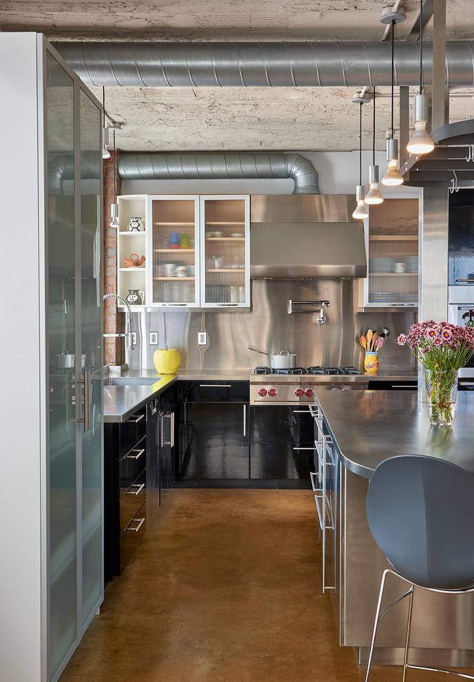 Mid-sized urban u-shaped concrete floor open concept kitchen photo in DC Metro with glass-front cabinets, stainless steel cabinets, stainless steel countertops, metallic backsplash, stainless steel appliances, an island and an undermount sink