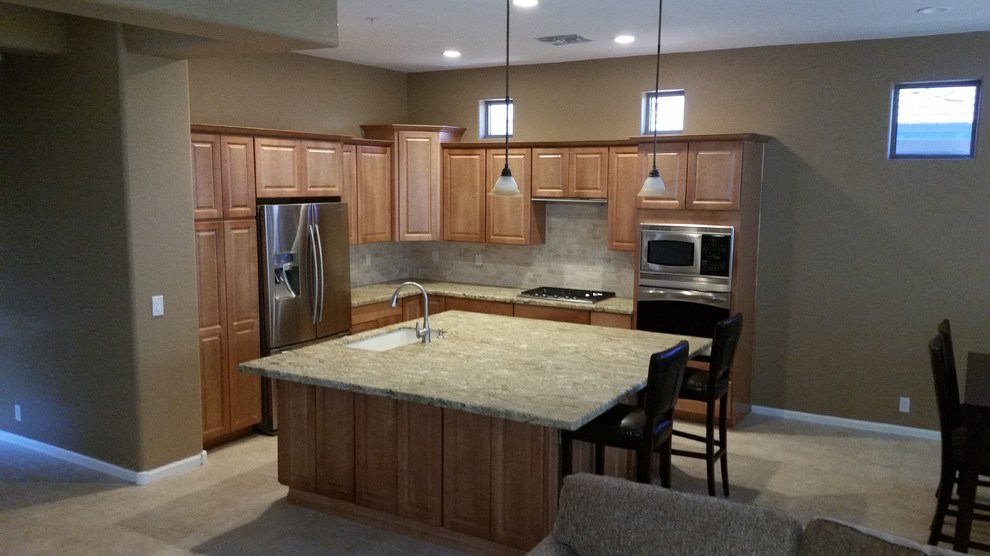 Inspiration for a mid-sized timeless l-shaped ceramic tile and beige floor eat-in kitchen remodel in Phoenix with an undermount sink, raised-panel cabinets, light wood cabinets, granite countertops, beige backsplash, stone tile backsplash, stainless steel appliances and an island