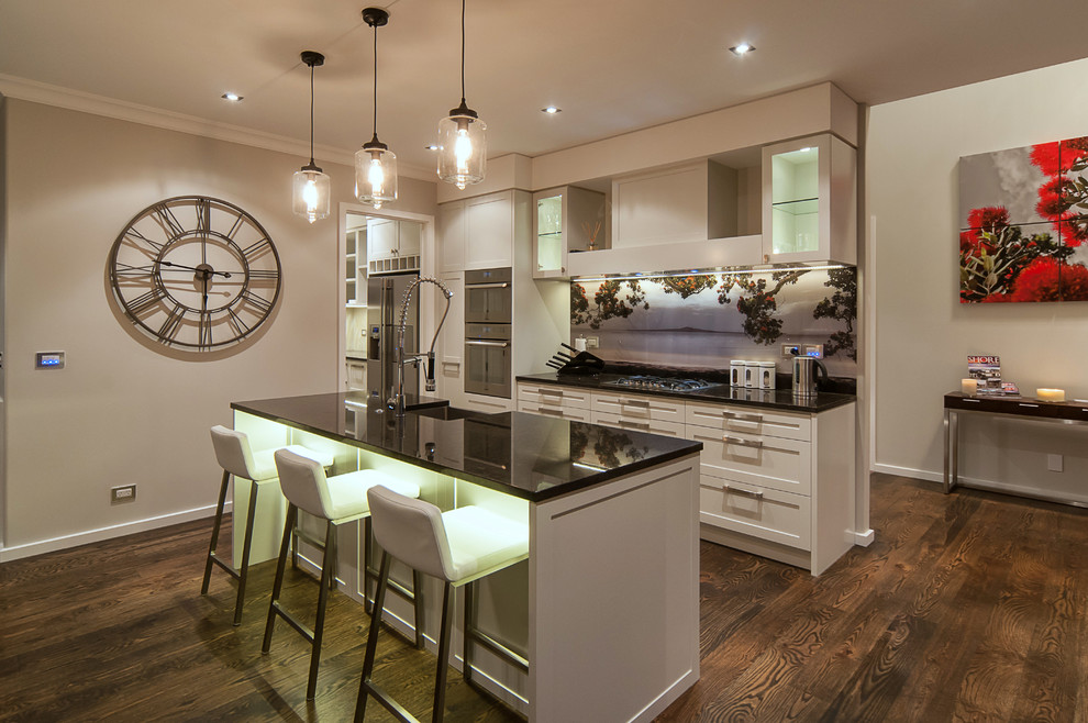 Zweizeilige Klassische Küche mit Landhausspüle, Schrankfronten im Shaker-Stil, weißen Schränken, Küchengeräten aus Edelstahl, dunklem Holzboden und Kücheninsel in Auckland