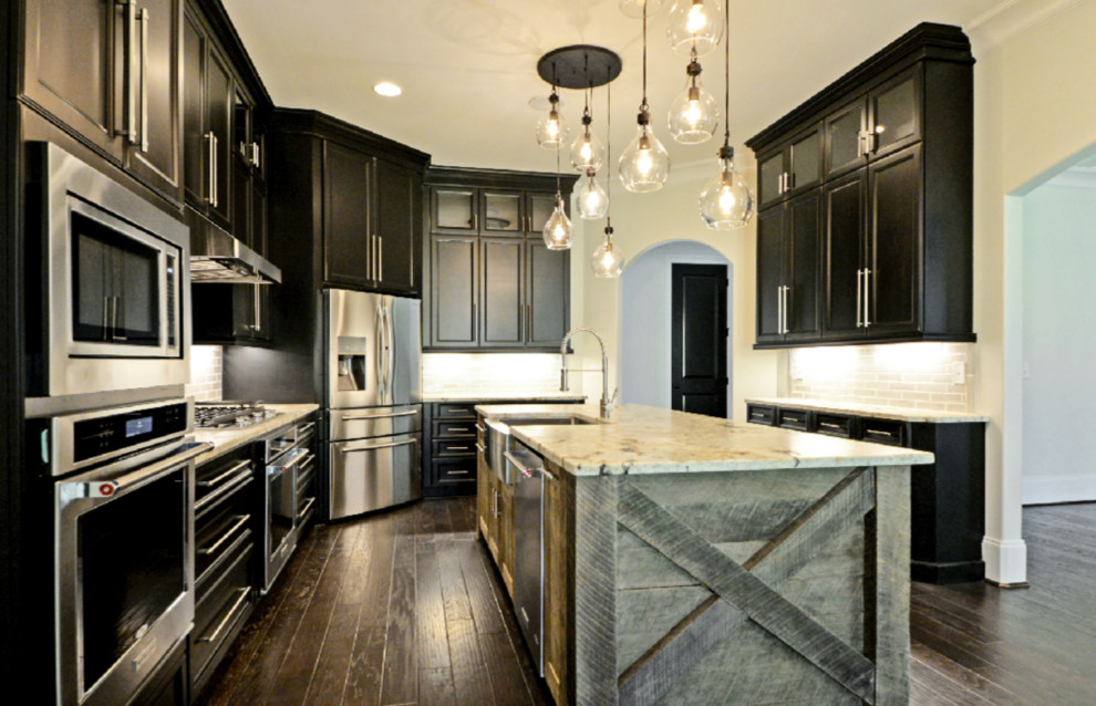 Mid-sized transitional u-shaped dark wood floor and brown floor enclosed kitchen photo in Other with a farmhouse sink, recessed-panel cabinets, dark wood cabinets, granite countertops, gray backsplash, subway tile backsplash, stainless steel appliances and an island