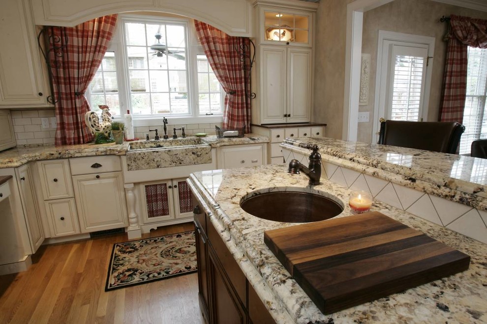 На фото: кухня с белыми фасадами, гранитной столешницей и фартуком из цементной плитки