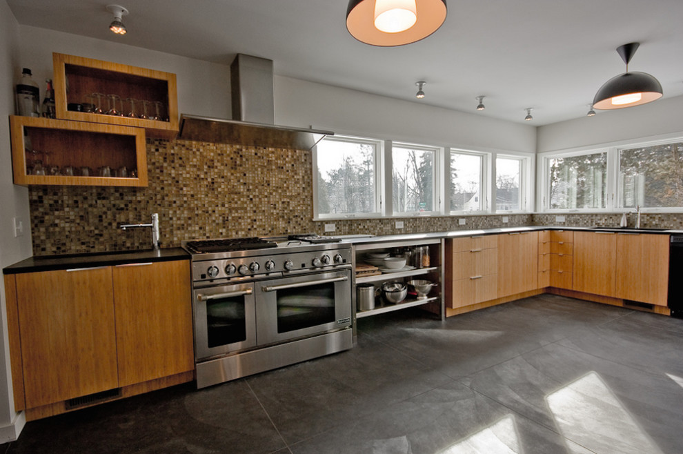 This is an example of a medium sized traditional single-wall kitchen/diner in Grand Rapids with a built-in sink, flat-panel cabinets, medium wood cabinets, composite countertops, multi-coloured splashback, glass tiled splashback, stainless steel appliances, concrete flooring and an island.