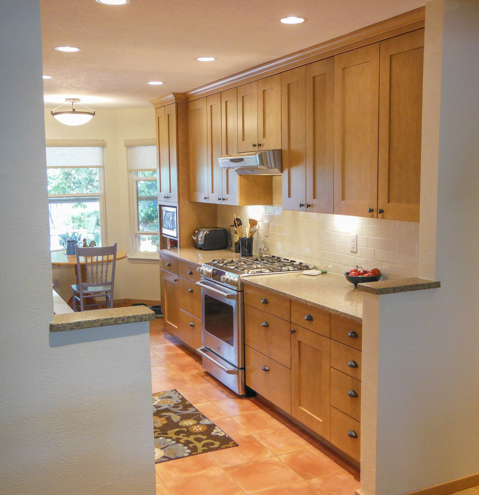 Example of a mid-sized classic galley terra-cotta tile eat-in kitchen design in Albuquerque with shaker cabinets, medium tone wood cabinets, quartzite countertops, white backsplash, subway tile backsplash and stainless steel appliances