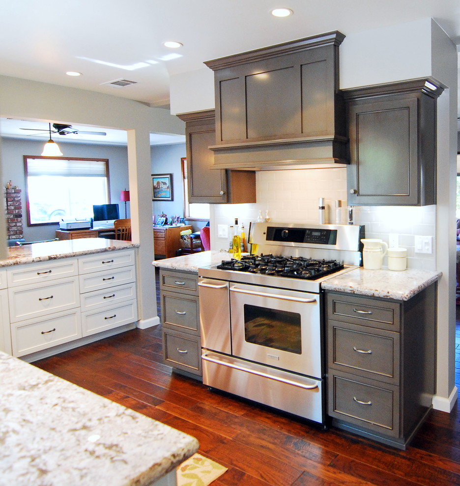 This is an example of a medium sized traditional galley enclosed kitchen in San Luis Obispo with a submerged sink, recessed-panel cabinets, grey cabinets, granite worktops, grey splashback, metro tiled splashback, stainless steel appliances, dark hardwood flooring and a breakfast bar.
