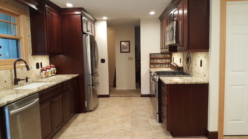 Foto på ett mellanstort medelhavsstil kök, med en undermonterad diskho, släta luckor, bruna skåp, granitbänkskiva, beige stänkskydd, stänkskydd i travertin, rostfria vitvaror, klinkergolv i porslin, en köksö och beiget golv