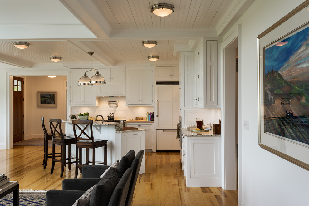 Klassische Wohnküche mit Schrankfronten mit vertiefter Füllung, weißen Schränken, Granit-Arbeitsplatte und Küchenrückwand in Weiß in New York