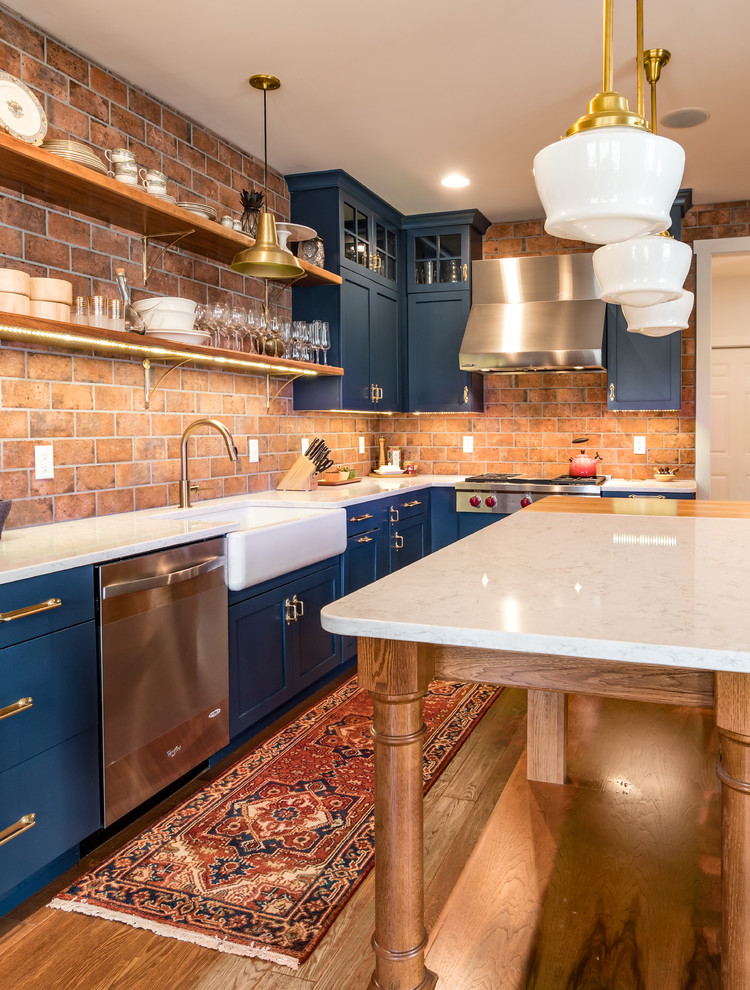 Eklektisk inredning av ett kök, med en rustik diskho, skåp i shakerstil, blå skåp, bänkskiva i kvartsit, mellanmörkt trägolv och en köksö