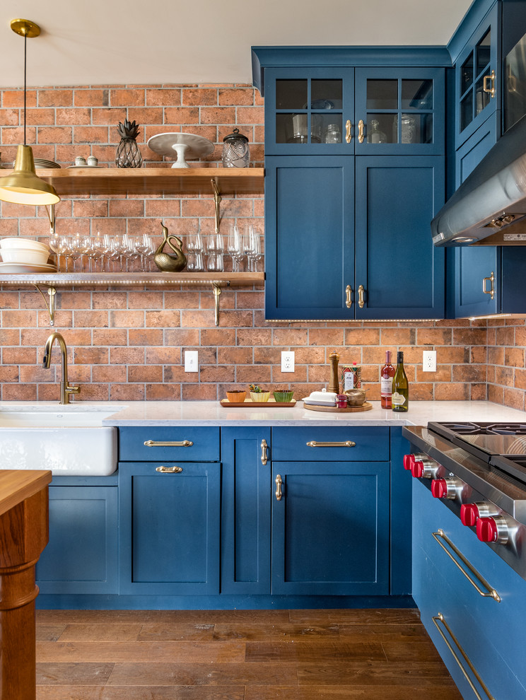 Idéer för lantliga kök, med en rustik diskho, skåp i shakerstil, blå skåp, bänkskiva i kvartsit, mellanmörkt trägolv och en köksö