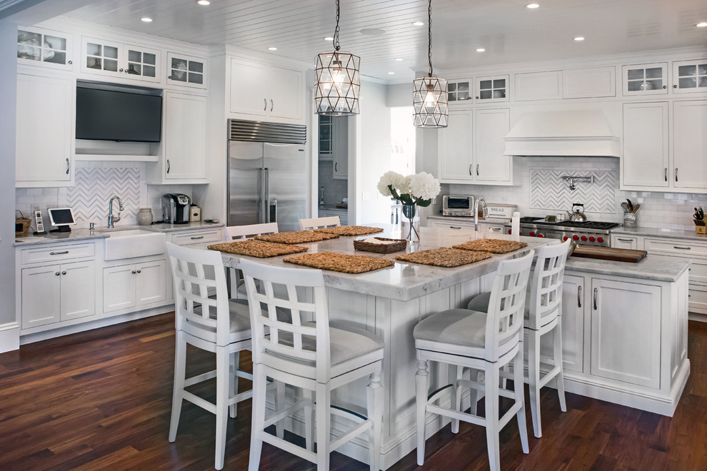 Inspiration for a large coastal dark wood floor open concept kitchen remodel in Boston with a farmhouse sink, shaker cabinets, white cabinets, quartzite countertops, white backsplash, mosaic tile backsplash, stainless steel appliances and two islands