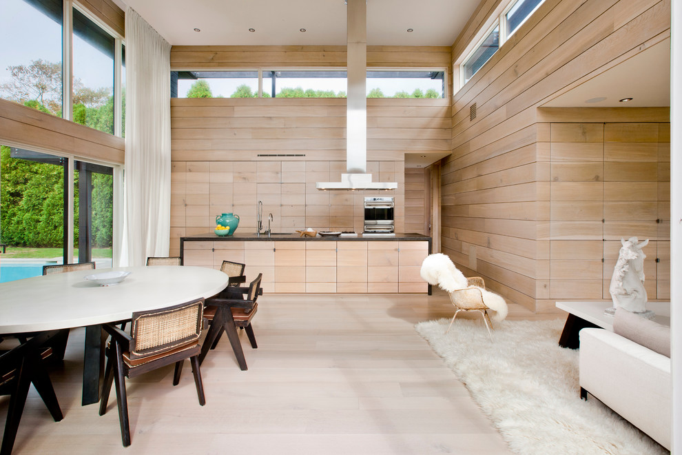 Immagine di una cucina scandinava di medie dimensioni con lavello sottopiano, ante lisce, ante in legno chiaro, elettrodomestici da incasso e parquet chiaro