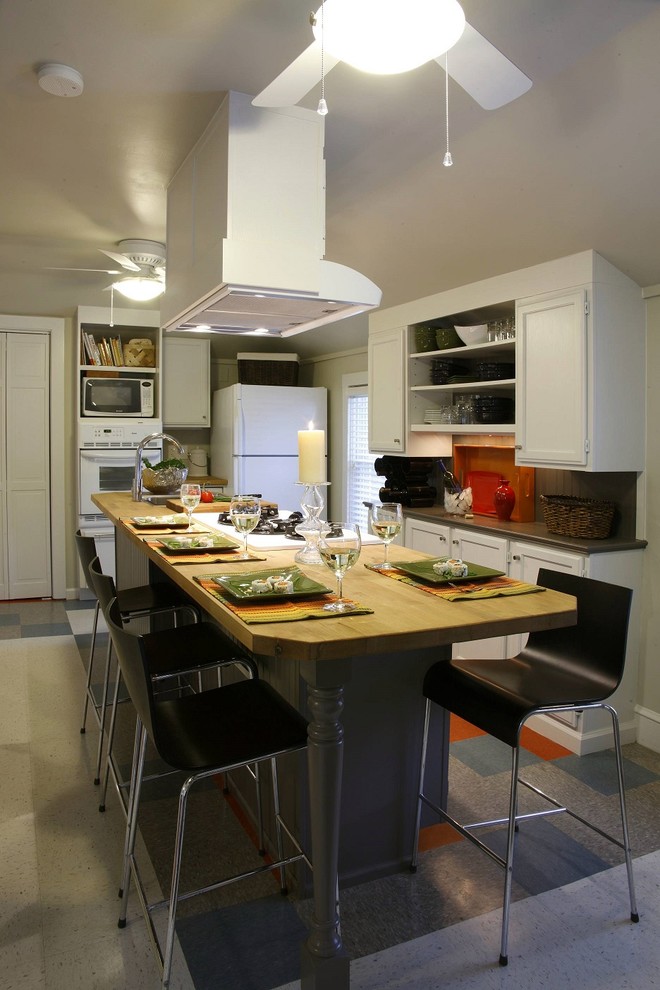 Идея дизайна: кухня в стиле фьюжн с обеденным столом, плоскими фасадами, деревянной столешницей и серым фартуком