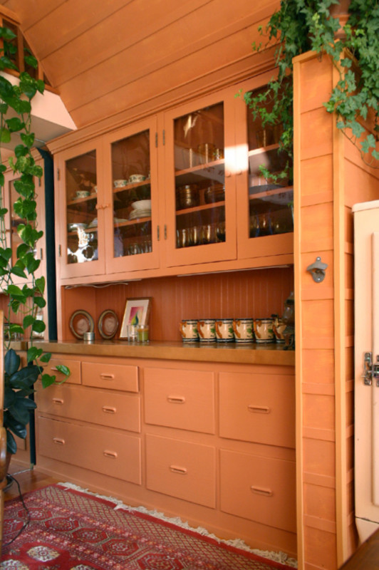 Idéer för att renovera ett litet eklektiskt linjärt kök och matrum, med en rustik diskho, luckor med upphöjd panel, beige skåp, träbänkskiva, brunt stänkskydd, färgglada vitvaror och ljust trägolv