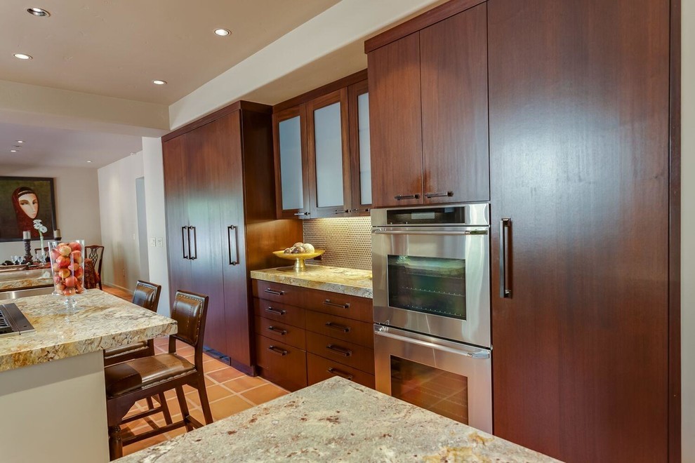 Example of a large trendy terra-cotta tile kitchen design with an undermount sink, shaker cabinets, dark wood cabinets, granite countertops, brown backsplash, metal backsplash, stainless steel appliances and an island