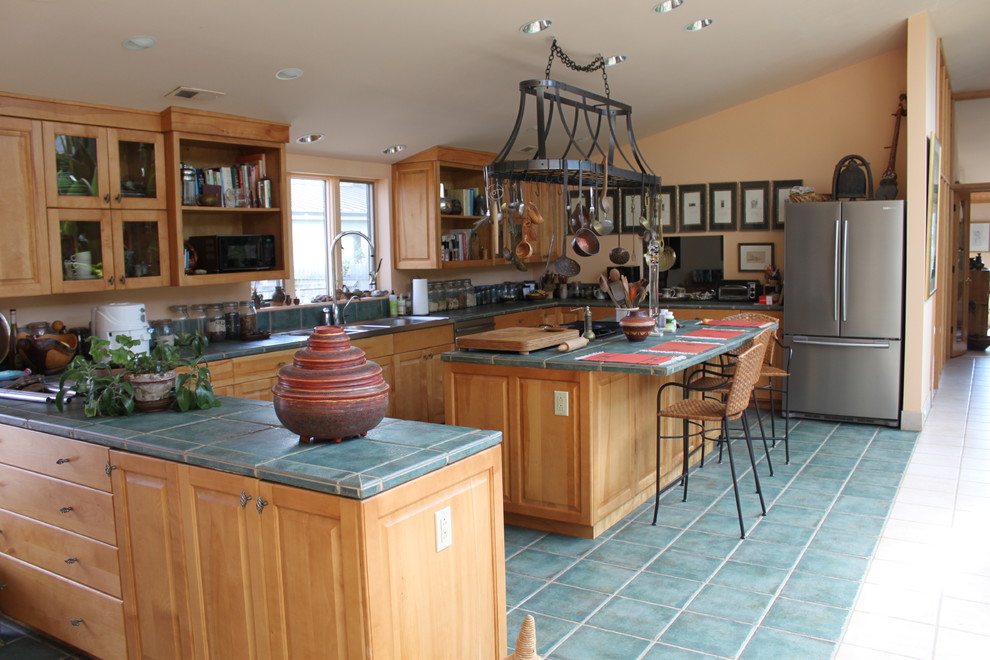ワシントンD.C.にある広い地中海スタイルのおしゃれなキッチン (ダブルシンク、レイズドパネル扉のキャビネット、淡色木目調キャビネット、タイルカウンター、シルバーの調理設備、セラミックタイルの床) の写真