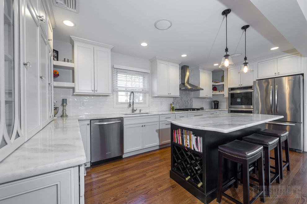 Large u-shaped plywood floor eat-in kitchen photo in New York with an undermount sink, flat-panel cabinets, white cabinets, quartzite countertops, white backsplash, porcelain backsplash, stainless steel appliances and an island