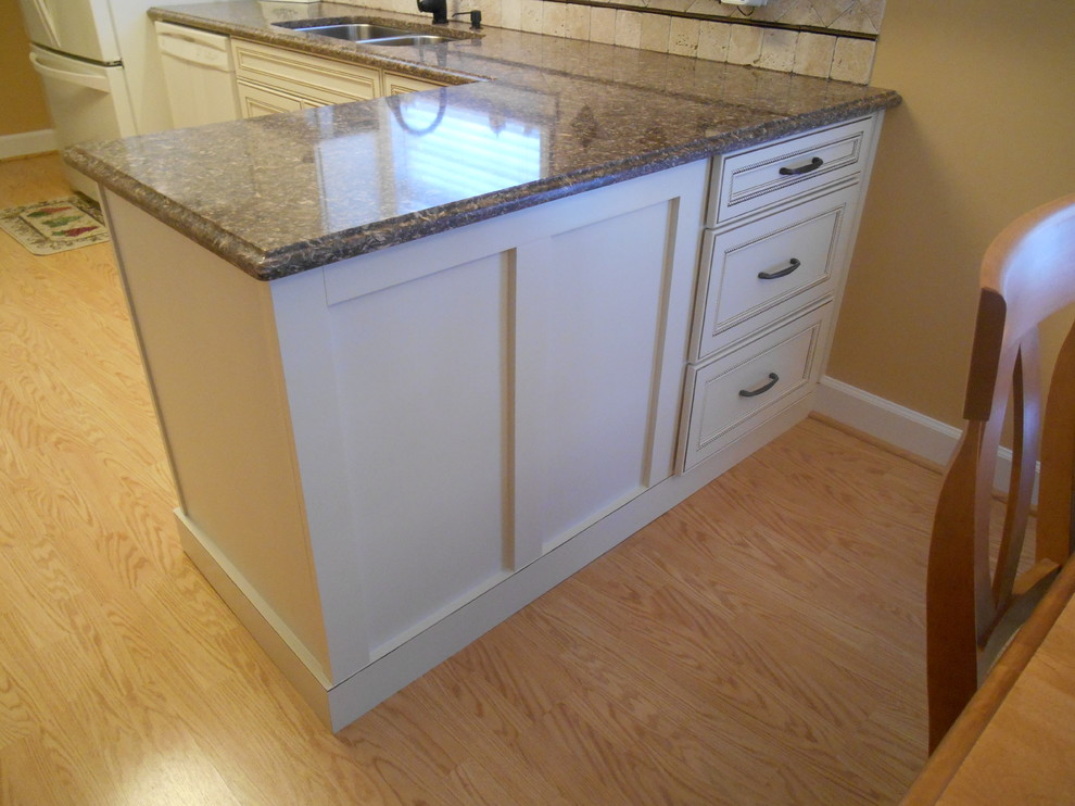 Example of a small classic galley light wood floor eat-in kitchen design in Birmingham with a double-bowl sink, flat-panel cabinets, white cabinets, quartz countertops, beige backsplash, stone tile backsplash, colored appliances and a peninsula