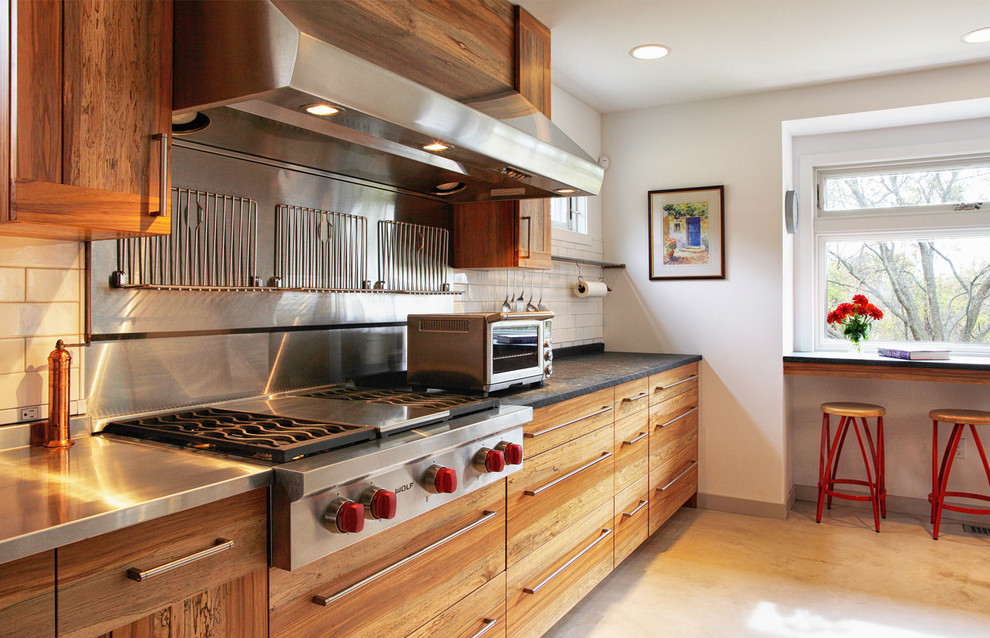 フィラデルフィアにある高級な中くらいなインダストリアルスタイルのおしゃれなキッチン (ステンレスカウンター、インセット扉のキャビネット、中間色木目調キャビネット、ベージュキッチンパネル、セラミックタイルのキッチンパネル、シルバーの調理設備) の写真