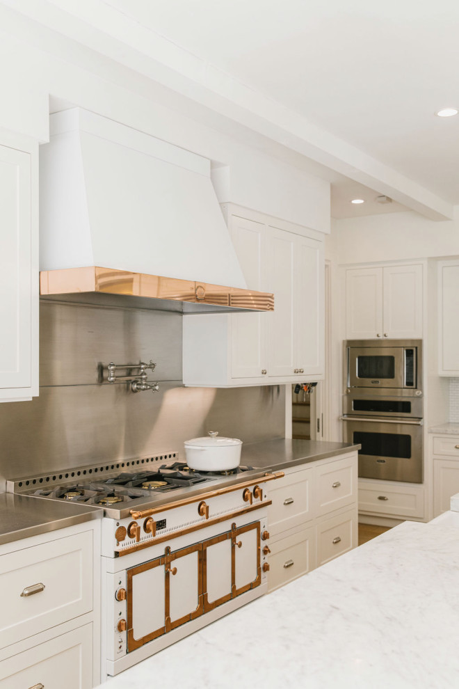 Idéer för ett stort lantligt vit kök, med en rustik diskho, luckor med infälld panel, vita skåp, marmorbänkskiva, stänkskydd med metallisk yta, stänkskydd i porslinskakel, vita vitvaror, ljust trägolv, en köksö och brunt golv
