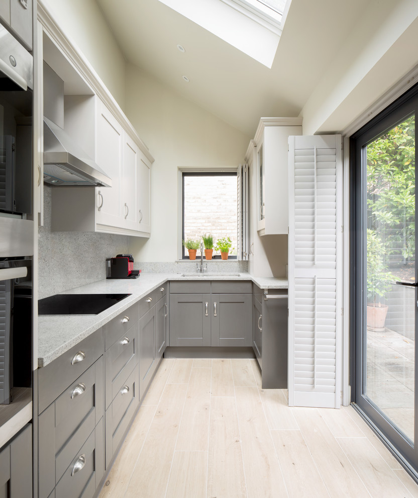 Small classic u-shaped kitchen in London with beige floors, a submerged sink, recessed-panel cabinets, grey cabinets, grey splashback, stainless steel appliances and no island.