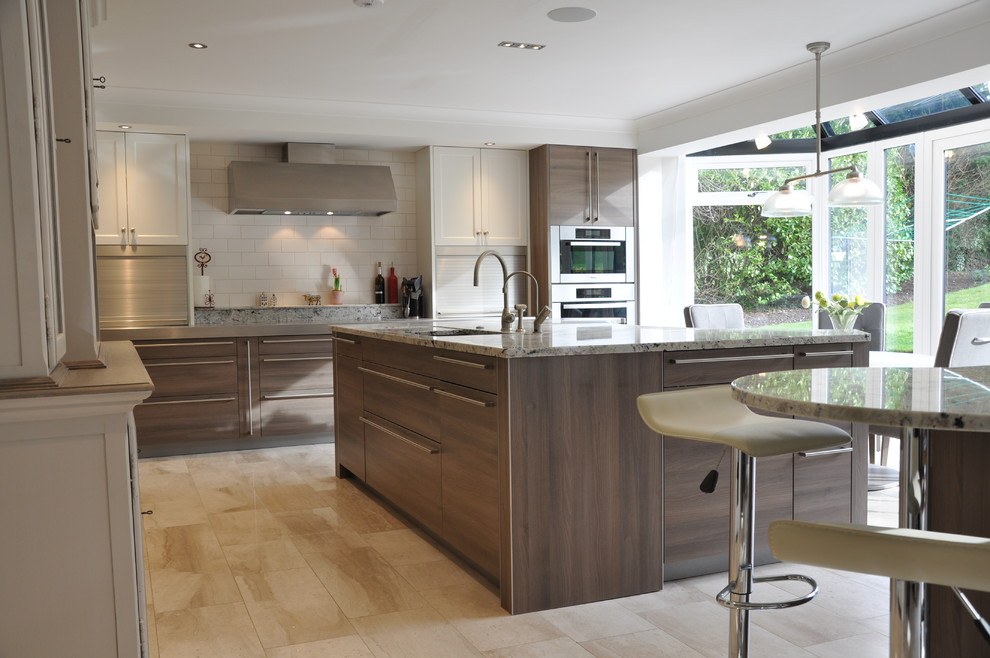 This is an example of a medium sized contemporary l-shaped kitchen/diner in Hertfordshire with a built-in sink, flat-panel cabinets, medium wood cabinets, granite worktops, beige splashback, ceramic splashback, stainless steel appliances, light hardwood flooring and an island.