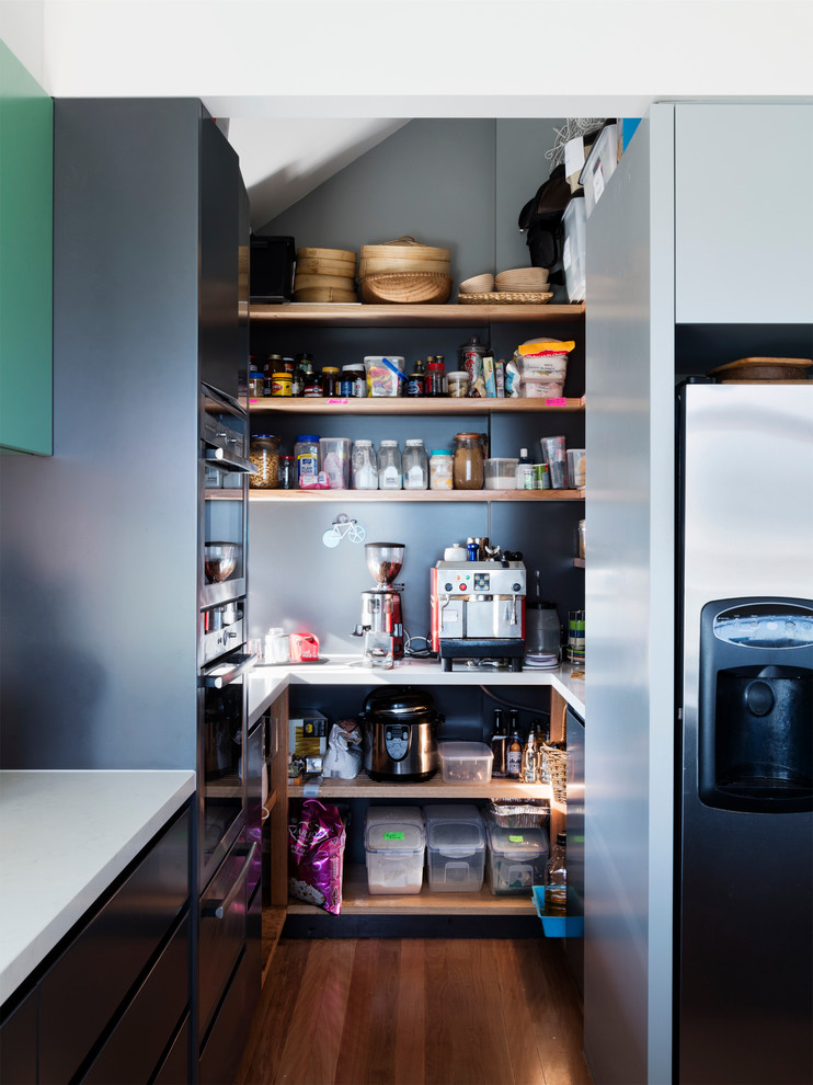 Zweizeilige, Mittelgroße Moderne Wohnküche ohne Insel mit grauen Schränken, Granit-Arbeitsplatte, Küchengeräten aus Edelstahl und braunem Holzboden in Melbourne