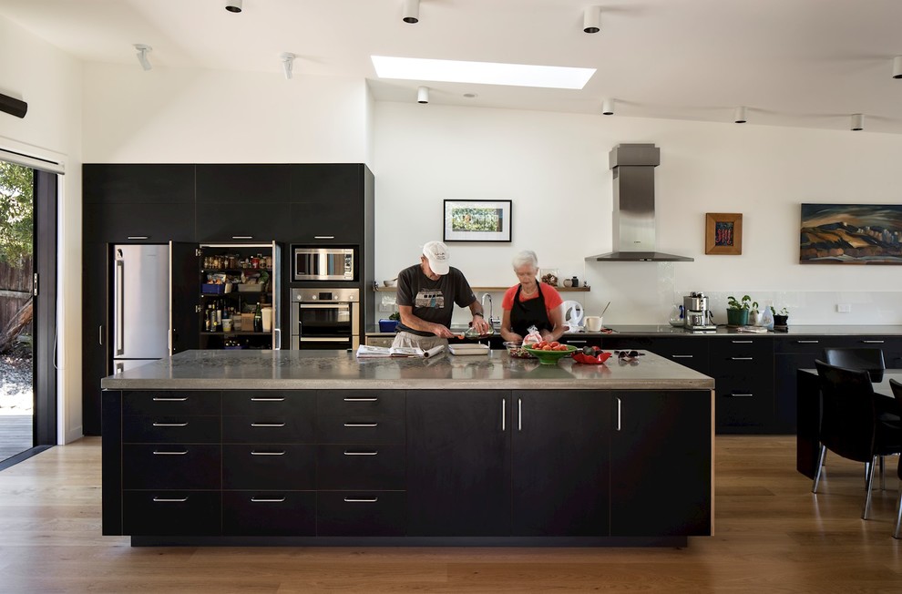 Offene, Große Moderne Küche mit hellem Holzboden, Kücheninsel und beigem Boden in Sonstige