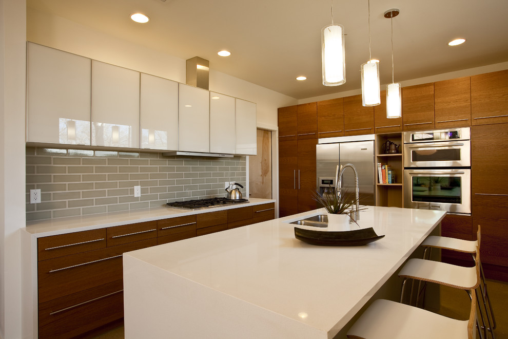 Mid-sized trendy u-shaped open concept kitchen photo in Austin with subway tile backsplash, stainless steel appliances, flat-panel cabinets, white cabinets, gray backsplash, a double-bowl sink, solid surface countertops and an island