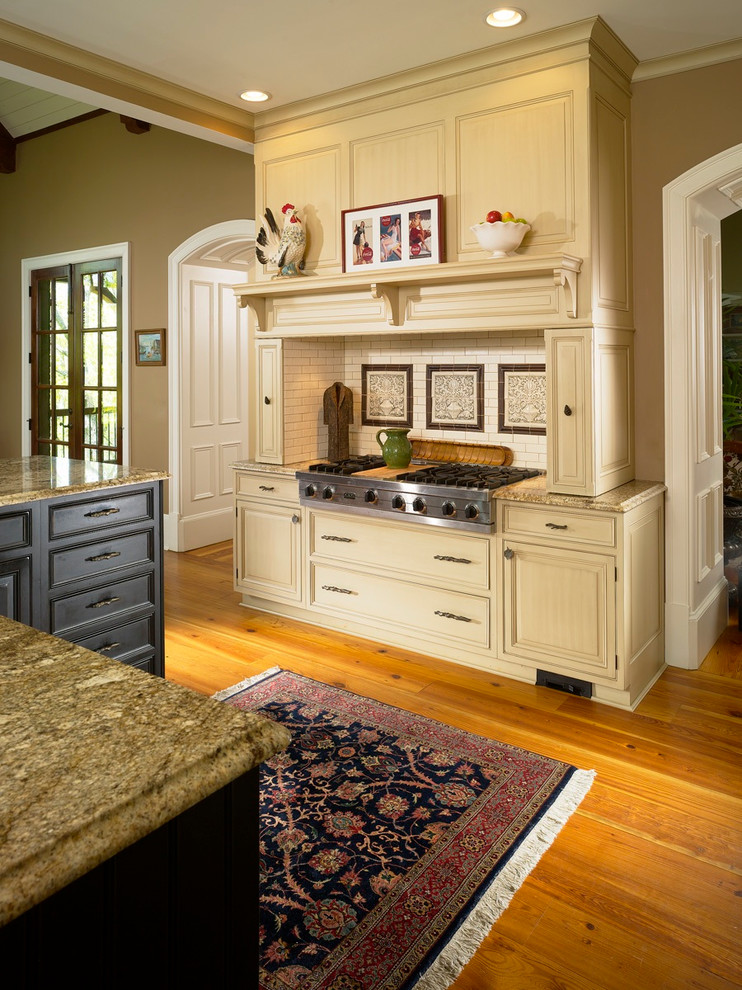 アトランタにあるトラディショナルスタイルのおしゃれなキッチン (レイズドパネル扉のキャビネット、ベージュのキャビネット、ベージュキッチンパネル、サブウェイタイルのキッチンパネル、シルバーの調理設備) の写真