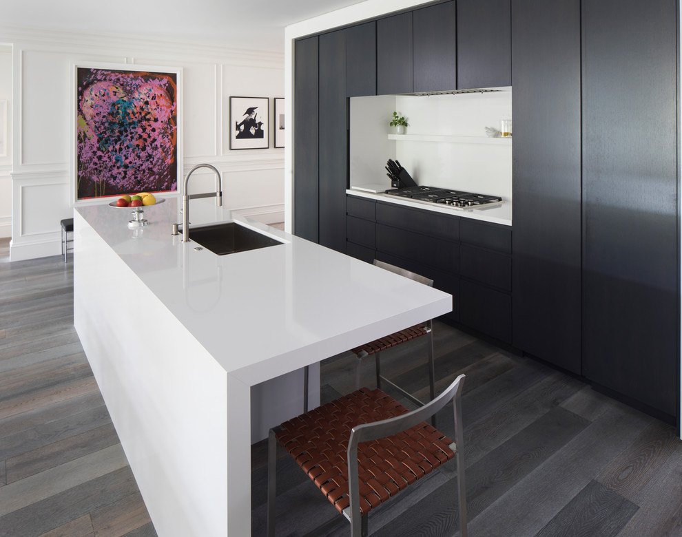 Mittelgroße Moderne Wohnküche in L-Form mit flächenbündigen Schrankfronten, Elektrogeräten mit Frontblende, braunem Holzboden, Kücheninsel, grauem Boden, Unterbauwaschbecken, schwarzen Schränken und Quarzit-Arbeitsplatte in Minneapolis