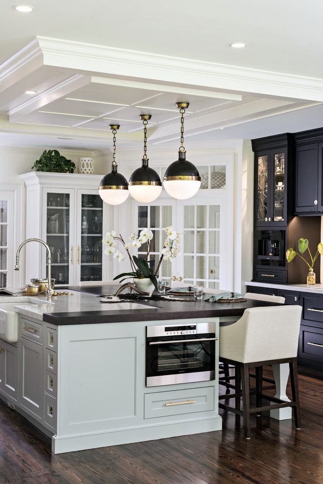 Klassische Küche mit Landhausspüle, Schrankfronten im Shaker-Stil, schwarzen Schränken, dunklem Holzboden, Kücheninsel und braunem Boden in Boston