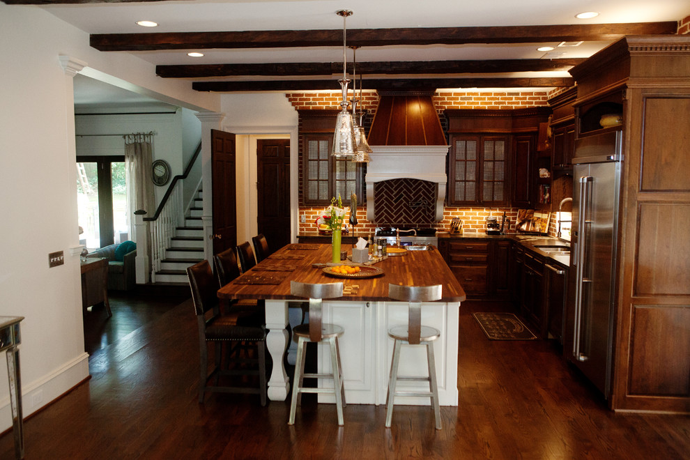 Eat-in kitchen - large farmhouse l-shaped dark wood floor eat-in kitchen idea in Atlanta with a double-bowl sink, raised-panel cabinets, dark wood cabinets, wood countertops, brown backsplash, brick backsplash, stainless steel appliances and an island