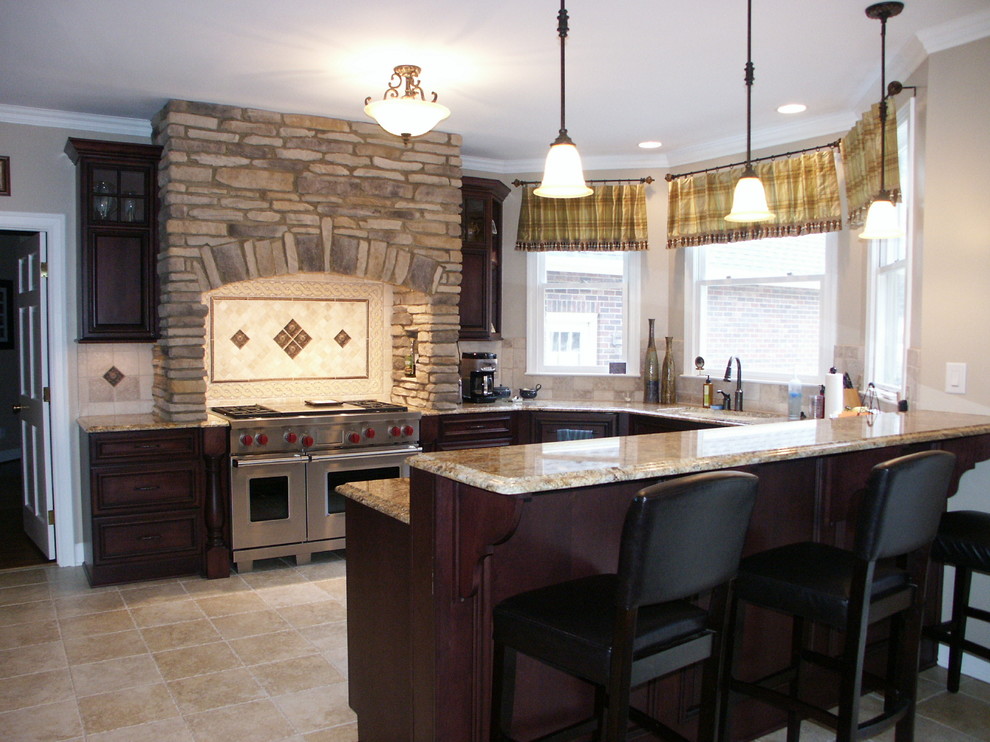 Exempel på ett stort klassiskt kök, med en undermonterad diskho, luckor med upphöjd panel, skåp i mörkt trä, granitbänkskiva, rostfria vitvaror, travertin golv, en halv köksö, beige stänkskydd och stänkskydd i stenkakel