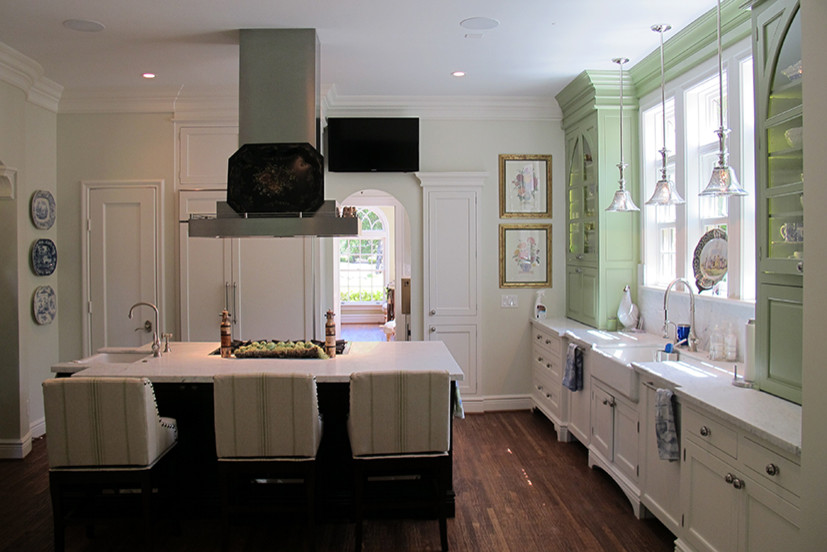 Bild på ett mellanstort vintage vit vitt kök, med en rustik diskho, luckor med glaspanel, gröna skåp, granitbänkskiva, rostfria vitvaror, mellanmörkt trägolv, en köksö och brunt golv