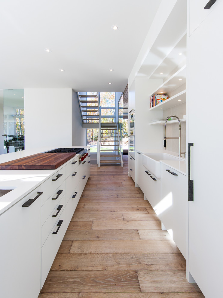 Diseño de cocina comedor moderna con fregadero sobremueble, armarios con paneles lisos, puertas de armario blancas y salpicadero blanco