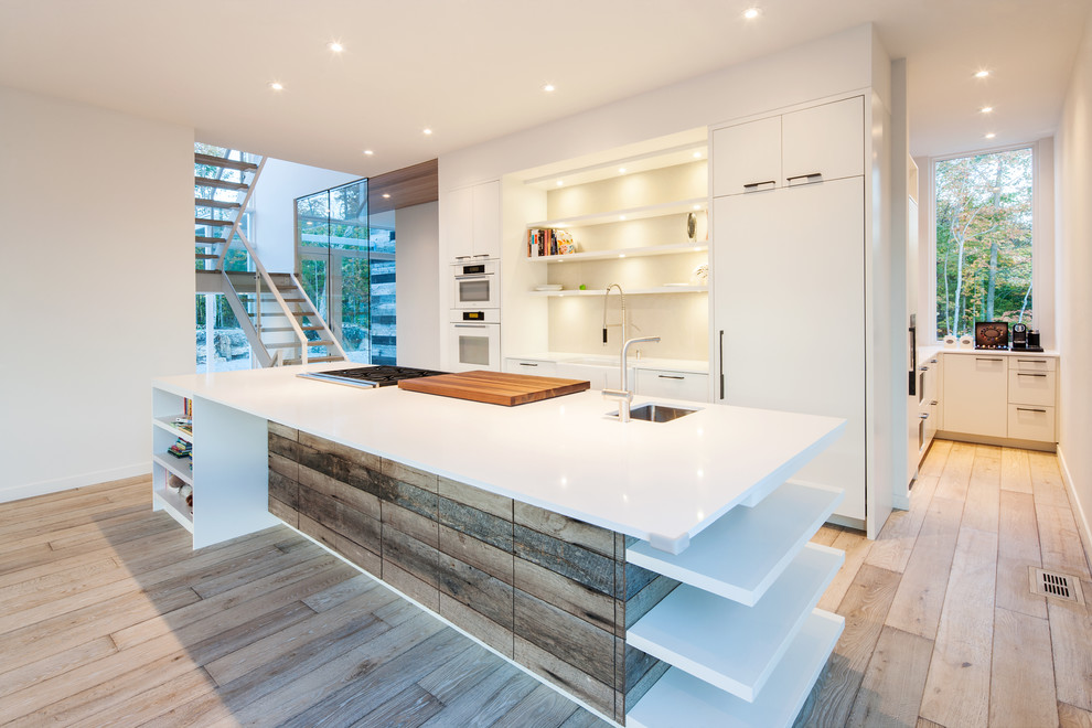 Zweizeilige Moderne Küche mit Unterbauwaschbecken, flächenbündigen Schrankfronten, weißen Schränken, Küchenrückwand in Weiß und weißen Elektrogeräten in Ottawa