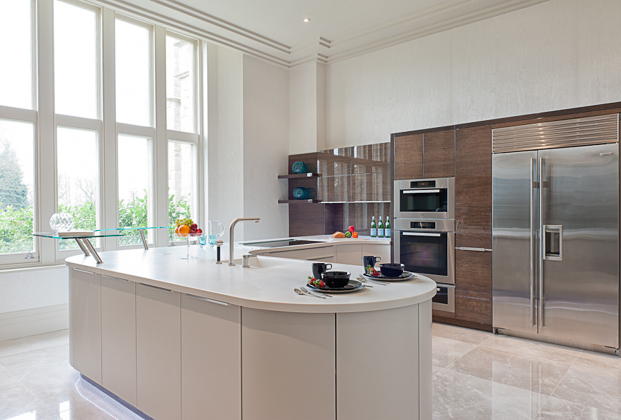 Immagine di un'ampia cucina minimal con lavello integrato, ante lisce, ante beige, elettrodomestici in acciaio inossidabile e pavimento in gres porcellanato