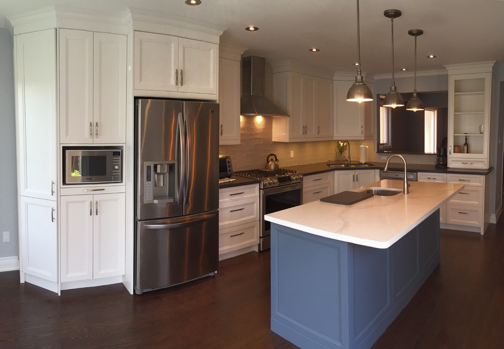 Example of a mid-sized transitional l-shaped dark wood floor eat-in kitchen design in Toronto with an undermount sink, recessed-panel cabinets, white cabinets, stainless steel appliances, an island, marble countertops, beige backsplash and porcelain backsplash