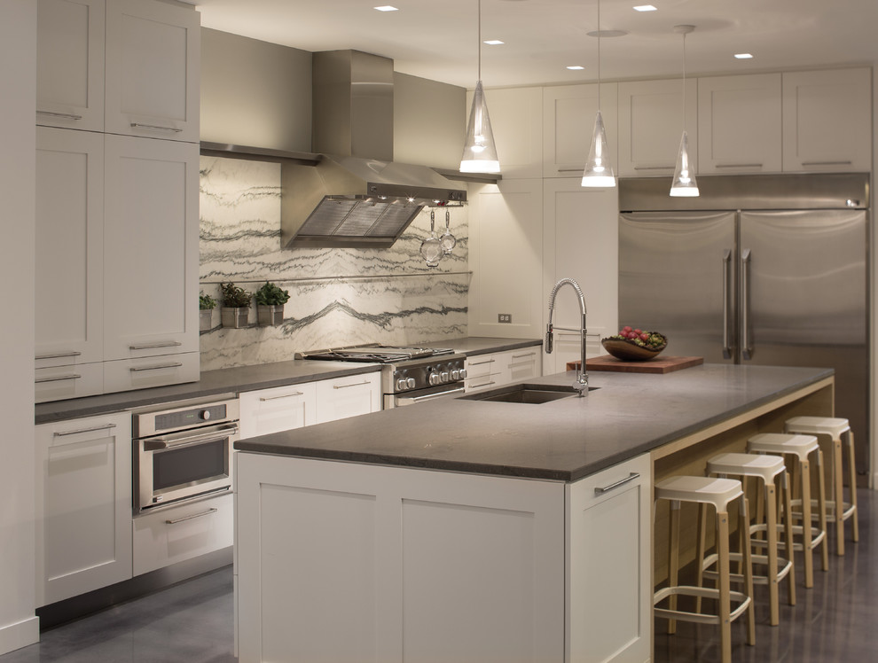 Moderne Küche in grau-weiß in L-Form mit Unterbauwaschbecken, Schrankfronten im Shaker-Stil, weißen Schränken, bunter Rückwand, Küchengeräten aus Edelstahl und Betonboden in Dallas
