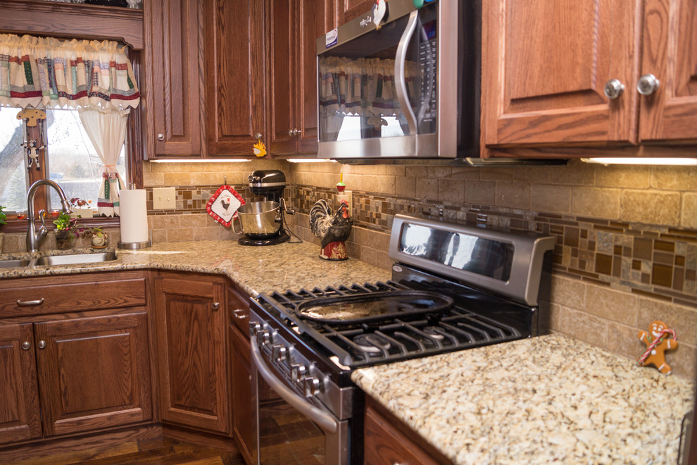 Exempel på ett stort lantligt kök, med en undermonterad diskho, luckor med upphöjd panel, skåp i mellenmörkt trä, bänkskiva i kvarts, flerfärgad stänkskydd, stänkskydd i keramik, rostfria vitvaror, mellanmörkt trägolv och en halv köksö