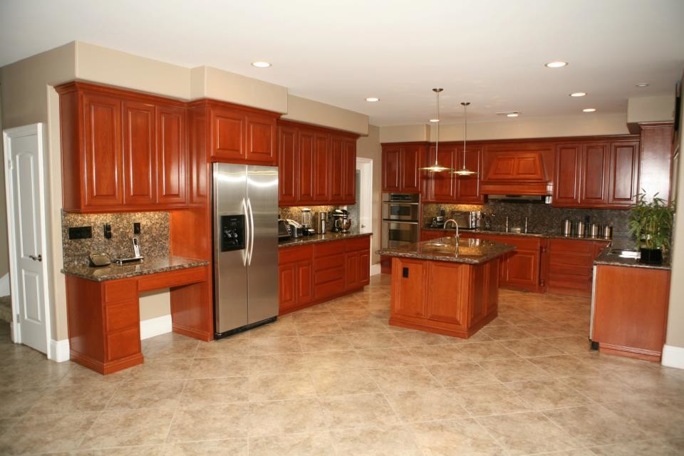 Example of a classic u-shaped eat-in kitchen design in San Diego with an undermount sink, raised-panel cabinets, medium tone wood cabinets, granite countertops, multicolored backsplash and stainless steel appliances