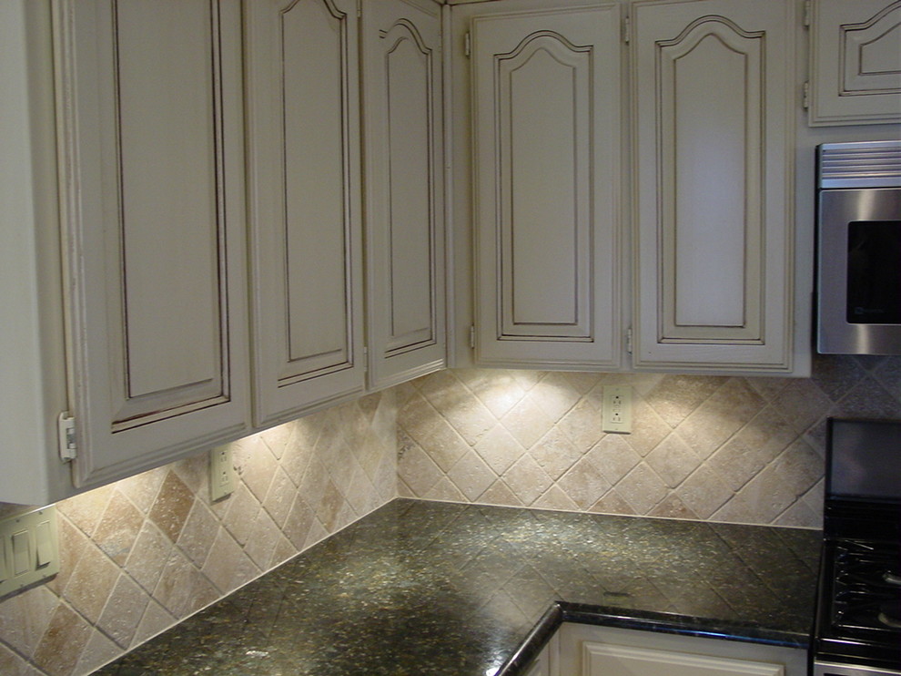 Example of a mid-sized transitional u-shaped dark wood floor kitchen design in Dallas with an undermount sink, raised-panel cabinets, beige cabinets, granite countertops, beige backsplash, stainless steel appliances, an island and stone tile backsplash