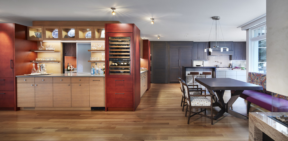 Eat-in kitchen - large transitional single-wall medium tone wood floor eat-in kitchen idea in Minneapolis with paneled appliances, an island, an undermount sink, shaker cabinets, gray cabinets, quartz countertops, white backsplash and ceramic backsplash