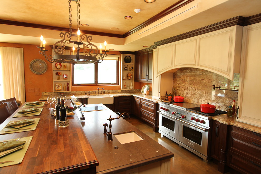 Foto de cocina actual con electrodomésticos de acero inoxidable, fregadero sobremueble y encimera de madera