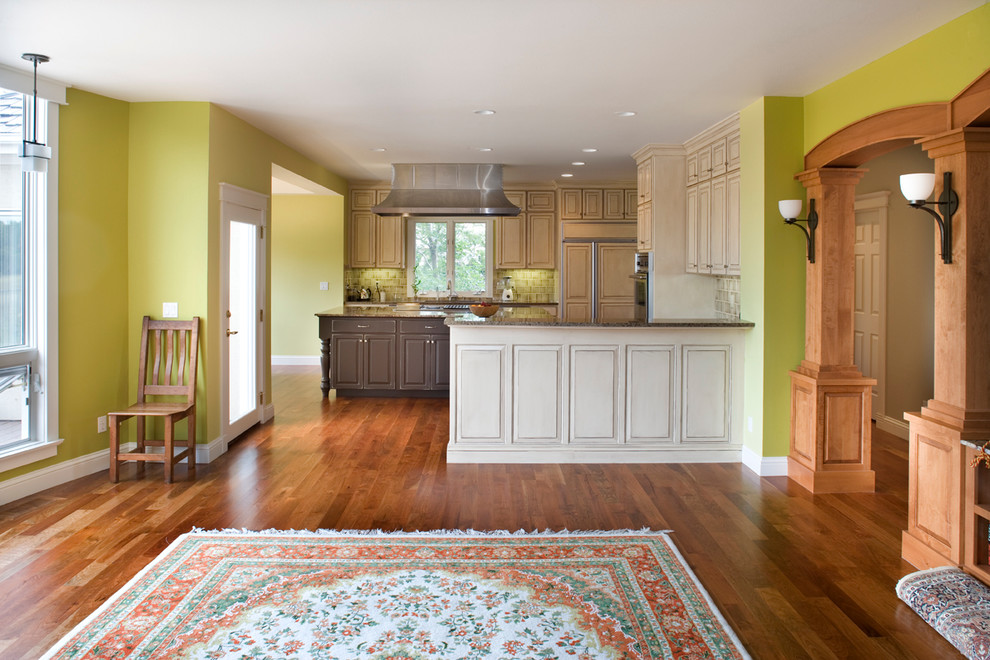 Example of a large classic u-shaped medium tone wood floor eat-in kitchen design in Boise with an undermount sink, raised-panel cabinets, distressed cabinets, granite countertops, green backsplash, ceramic backsplash, stainless steel appliances and an island