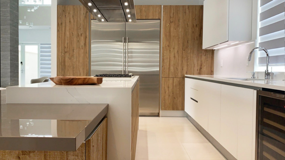 Modern inredning av ett mellanstort vit vitt kök, med en dubbel diskho, släta luckor, skåp i mellenmörkt trä, bänkskiva i kvarts, vitt stänkskydd, stänkskydd i skiffer, rostfria vitvaror, klinkergolv i porslin, en köksö och beiget golv