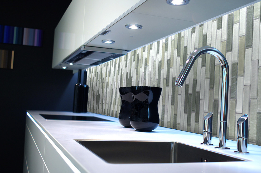 Esempio di una cucina lineare design chiusa e di medie dimensioni con lavello da incasso, ante lisce, ante bianche, paraspruzzi multicolore, paraspruzzi con piastrelle a mosaico e elettrodomestici neri