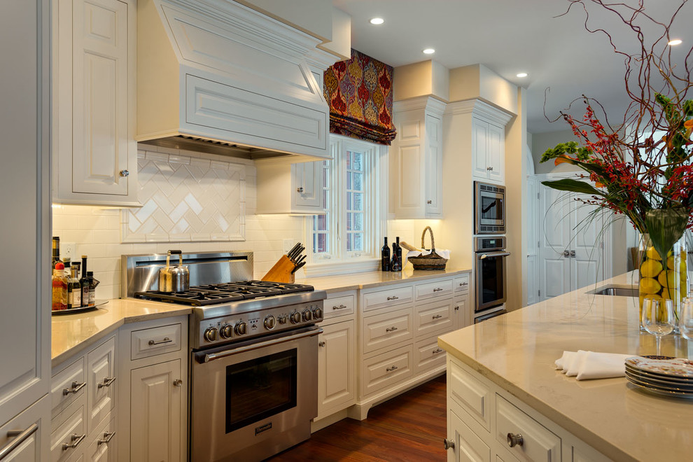 Large elegant l-shaped medium tone wood floor eat-in kitchen photo in Boston with an undermount sink, beaded inset cabinets, white cabinets, an island and white backsplash