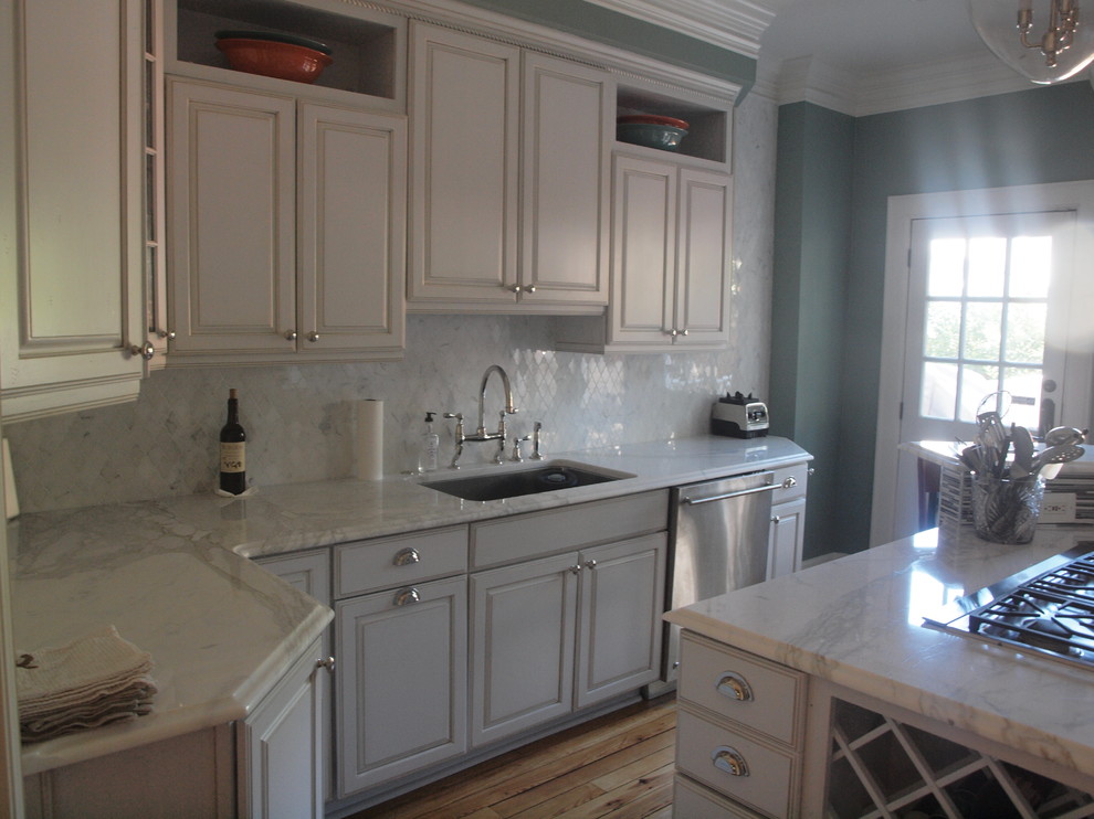 Bild på ett funkis kök, med en nedsänkt diskho, skåp i shakerstil, marmorbänkskiva, stänkskydd i glaskakel, rostfria vitvaror och ljust trägolv