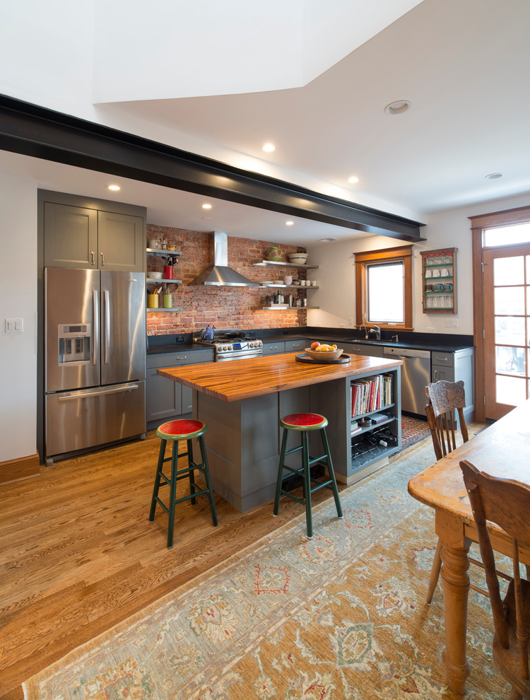ワシントンD.C.にある中くらいなインダストリアルスタイルのおしゃれなキッチン (フラットパネル扉のキャビネット、グレーのキャビネット、ドロップインシンク、大理石カウンター、シルバーの調理設備) の写真