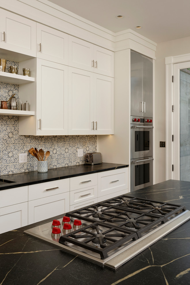 Inspiration for a large traditional galley kitchen pantry in DC Metro with a submerged sink, shaker cabinets, stainless steel cabinets, soapstone worktops, multi-coloured splashback, ceramic splashback, stainless steel appliances, medium hardwood flooring and an island.